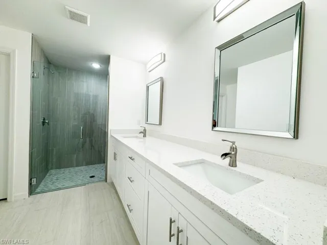 Bathroom featuring vanity and an enclosed shower