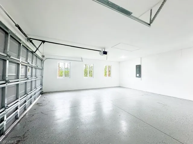 Garage featuring a garage door opener and electric panel