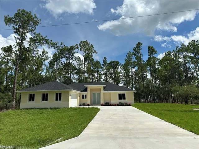 Ranch-style house with a front lawn and a garage