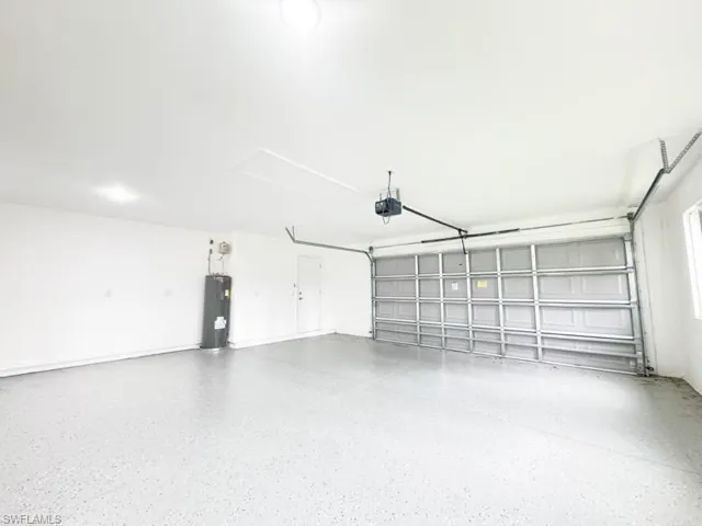 Garage featuring water heater and a garage door opener