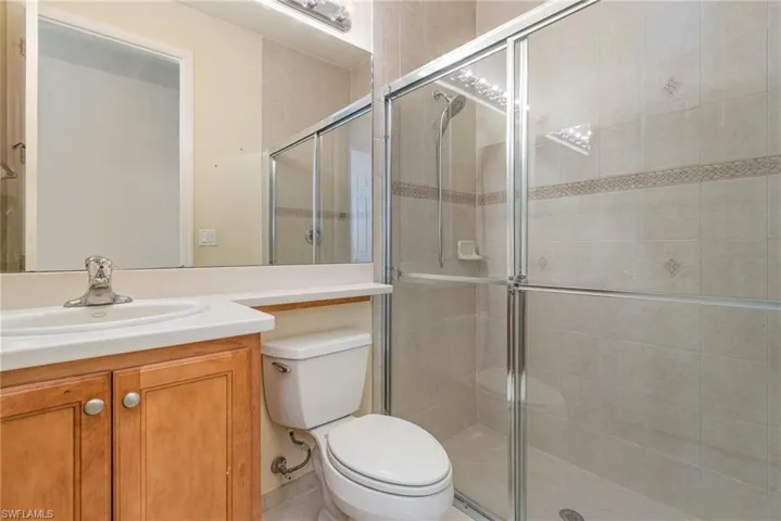 Bathroom 1 (guest) - Downstairs featuring vanity with oversized mirror, a glass shower box.
