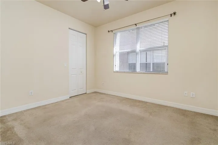 Guest Bedroom 1 - Downstairs - featuring ceiling fan and light carpet.