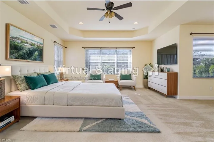 Virtual Staged photo-Carpeted bedroom with baseboards, a tray ceiling, multiple windows, and visible vents