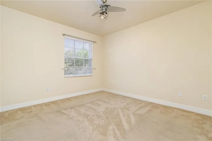 Bedroom # 6, view to the street/amenities. light colored carpet and ceiling fan.