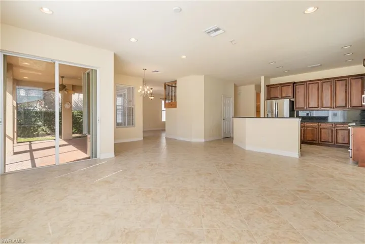 Kitchen with pendant lighting, stainless steel fridge, an inviting chandelier, and a kitchen featuring a breakfast bar.