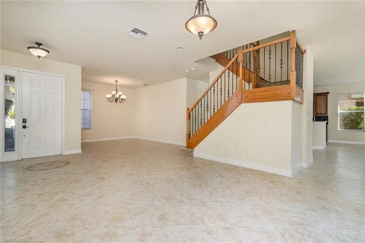 Unfurnished living room with an inviting chandelier