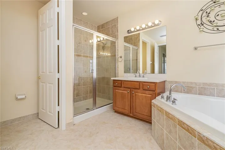 Bathroom featuring walk in shower and closed toilet room for privacy.