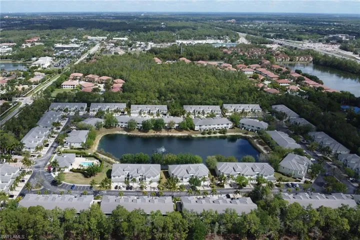 Aerial perspective showcasing a residential community centered around a tranquil pond