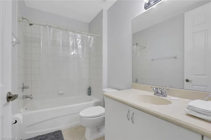 Bathroom with a single vanity featuring a built-in sink and a large mirror