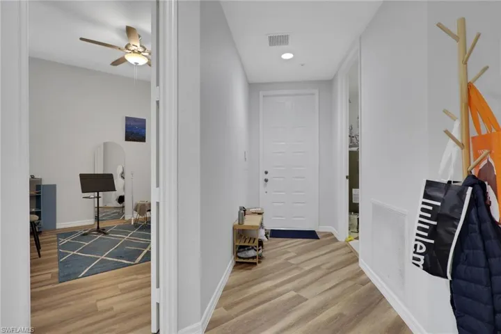 Entryway featuring durable wood-finish flooring, recessed lighting, and a paneled entry door