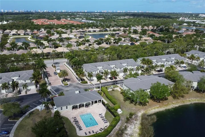 Aerial perspective showcasing a residential community with a central pool and clubhouse