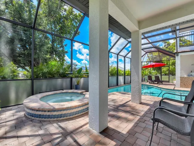 View of swimming pool with an in ground hot tub, a patio, and a lanai