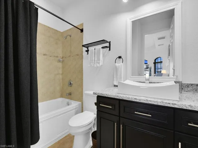 Full bathroom featuring tile patterned flooring, vanity, shower / tub combo, and toilet