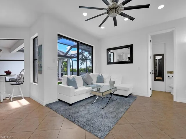 Living room with ceiling fan and light tile patterned floors