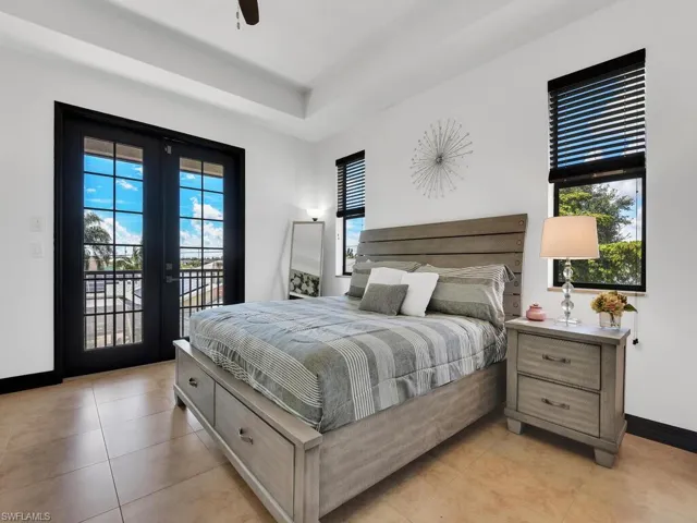 Tiled bedroom featuring access to exterior and ceiling fan