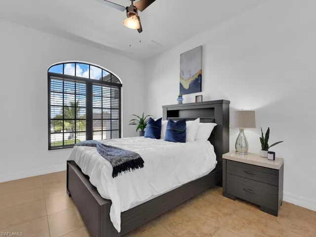 Tiled bedroom featuring ceiling fan