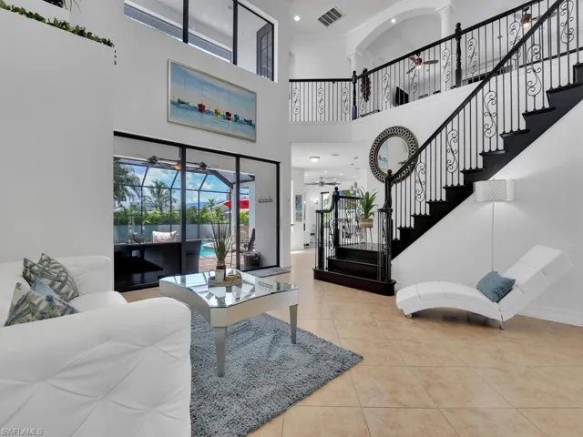 Living room featuring tile patterned floors, ceiling fan, and a towering ceiling