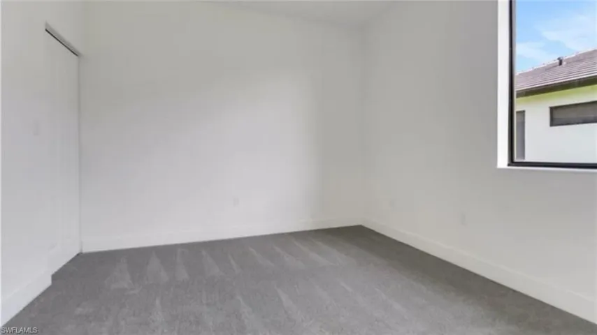Unfurnished room featuring carpet and baseboards
