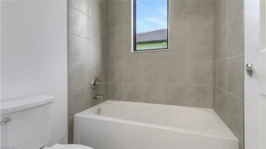 Full bath featuring washtub / shower combination and toilet