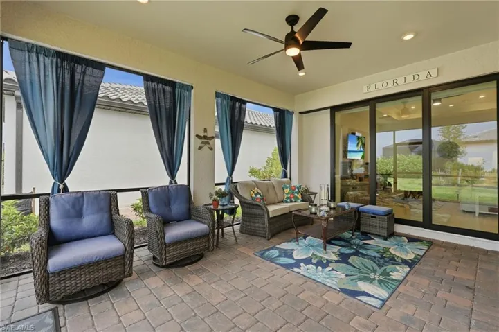 Screened lanai featuring paver flooring and an overhead ceiling fan