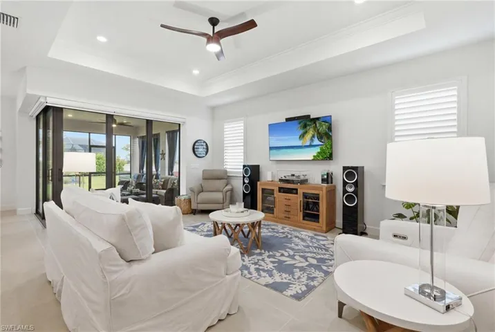 Recessed lighting illuminates a tray ceiling and contemporary ceiling fan