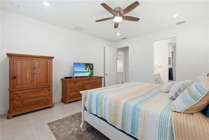 Bright bedroom featuring a ceiling fan, recessed lighting, and tile flooring