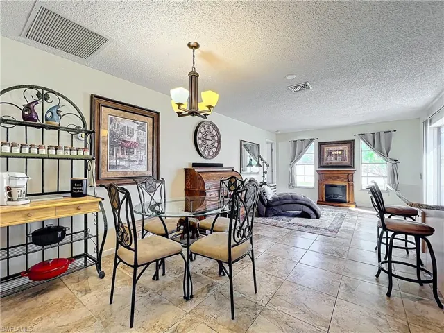 Dining area with a textured ceiling and a chandelier