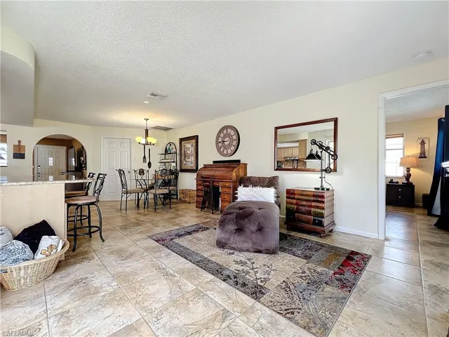 Living room with a textured ceiling and a chandelier