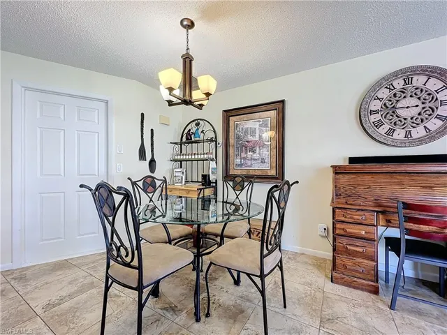 Dining space with a textured ceiling and a notable chandelier