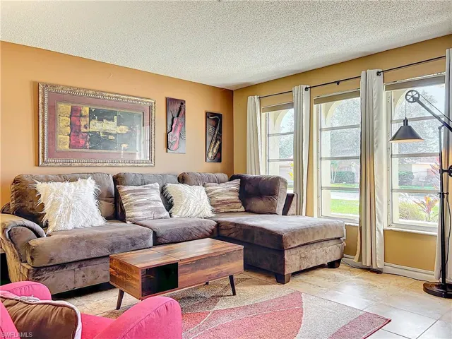 Tiled living room featuring a textured ceiling