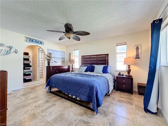 Bedroom featuring ceiling fan and a textured ceiling