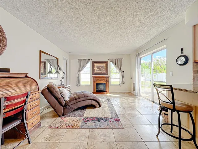 Living room featuring a textured ceiling and light tile patterned floors