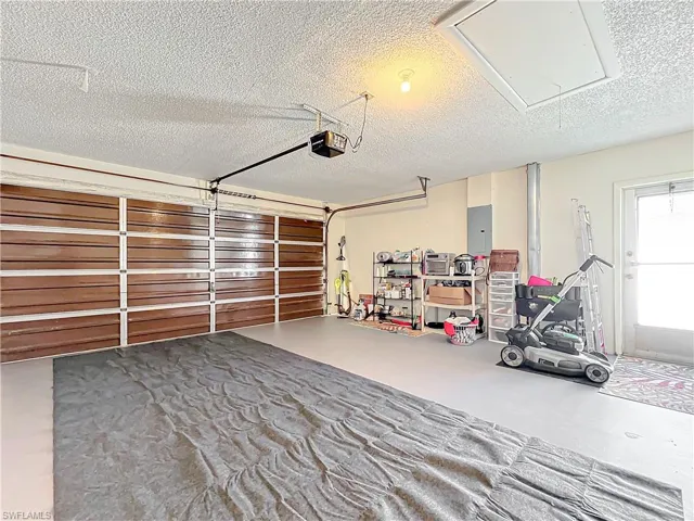 Garage with electric panel and a garage door opener