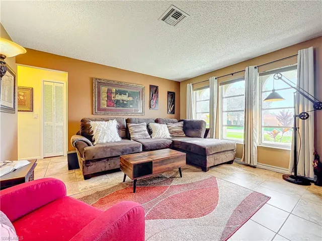 Living room with a textured ceiling and light tile patterned floors