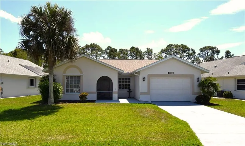 Ranch-style house with a front yard, stucco siding, concrete driveway, and a garage