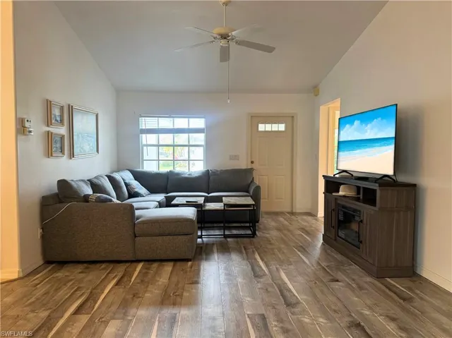 Living area featuring lofted ceiling, hardwood / wood-style floors, and a ceiling fan