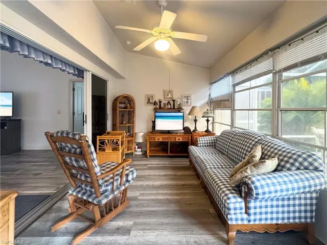 Living room featuring vaulted ceiling, wood finished floors, and ceiling fan
