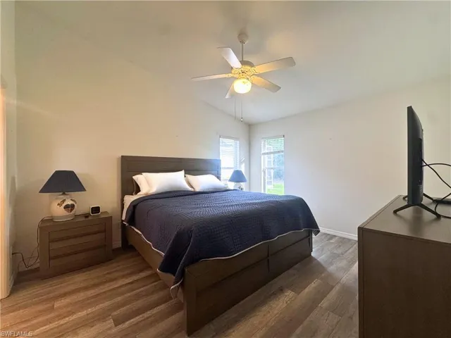 Bedroom featuring lofted ceiling, wood finished floors, and ceiling fan