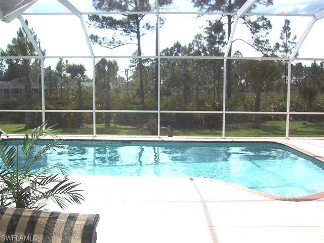 Swimming pool with glass enclosure and a patio area