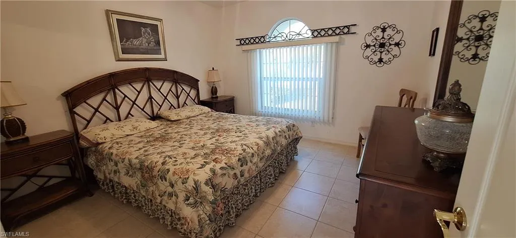Bedroom with light tile patterned flooring and baseboards