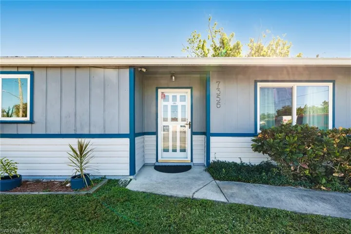 Entrance to property with a lawn