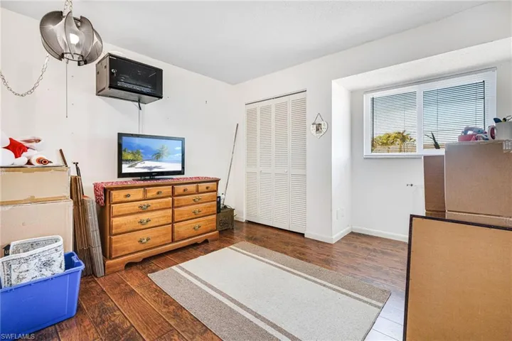 Bedroom featuring dark hardwood / wood-style flooring and a closet