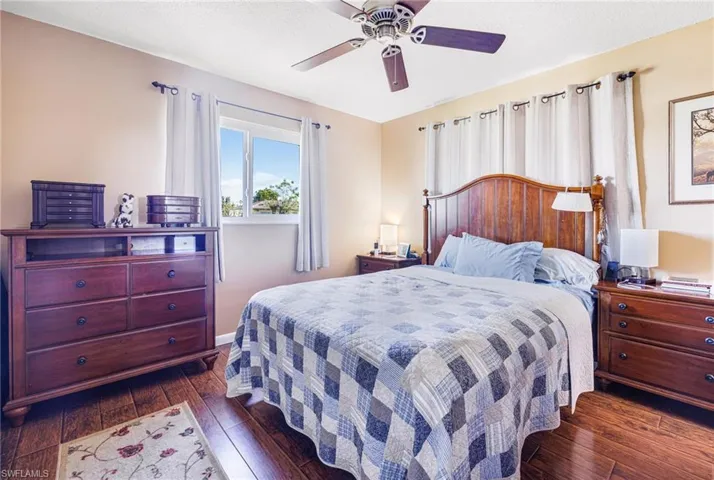 Bedroom with ceiling fan and dark hardwood / wood-style flooring