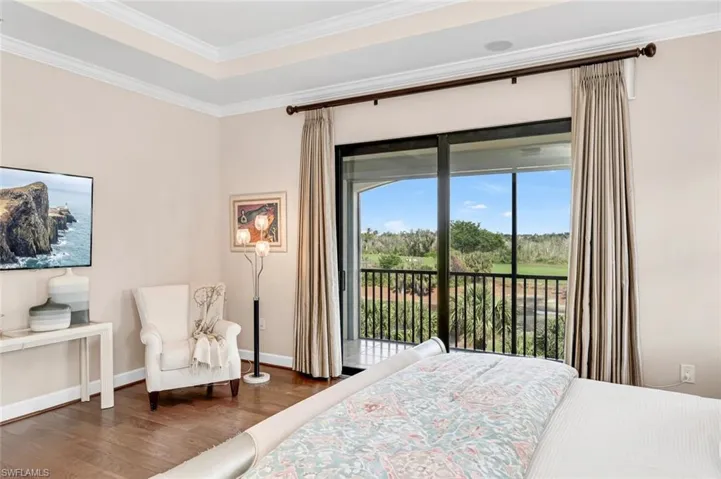 Bedroom with ornamental molding, dark hardwood / wood-style flooring, and access to outside