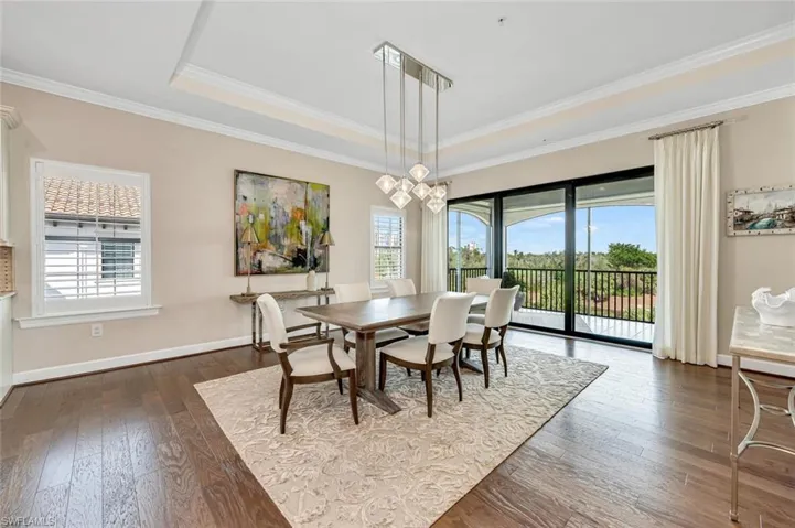 Dining room with ornamental molding, plenty of natural light, and dark hardwood / wood-style floors