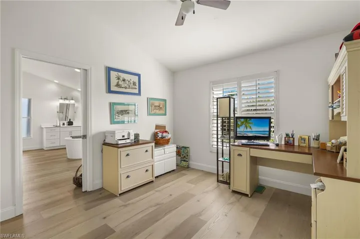 Office area featuring lofted ceiling, light wood-type flooring, and ceiling fan