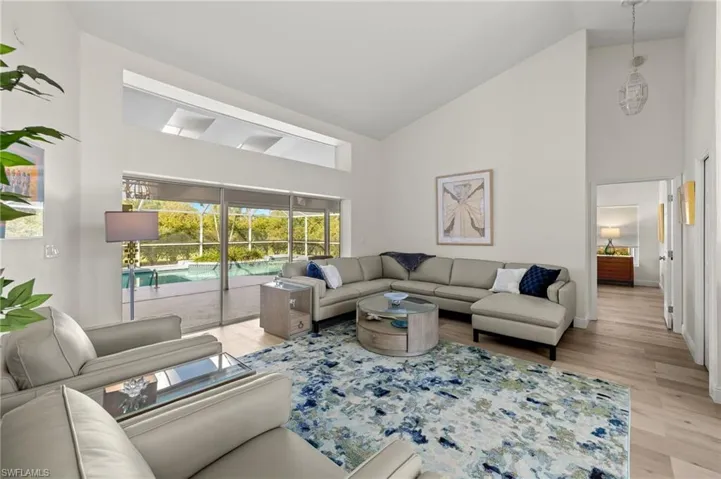 Living room featuring high vaulted ceiling and light hardwood / wood-style flooring