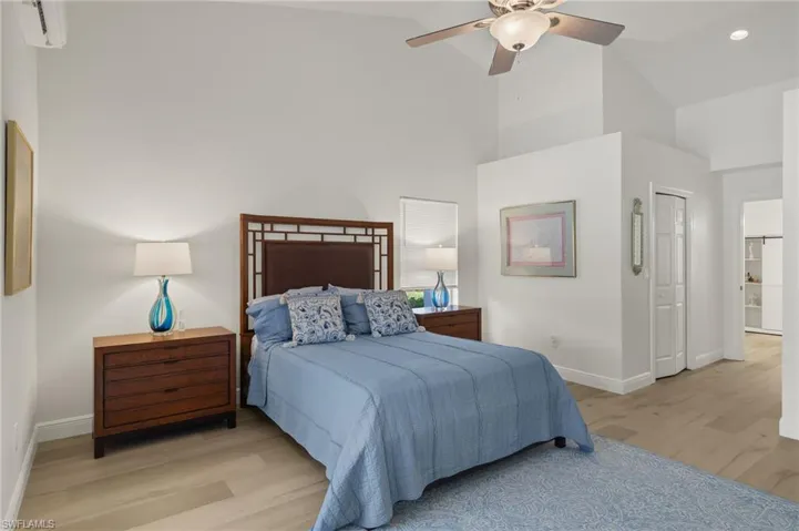 Bedroom featuring high vaulted ceiling, light hardwood / wood-style floors, and ceiling fan