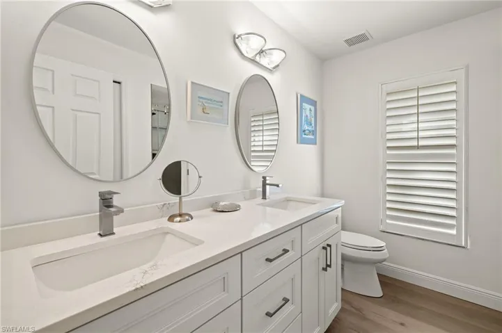Bathroom featuring toilet, vanity, and wood-type flooring