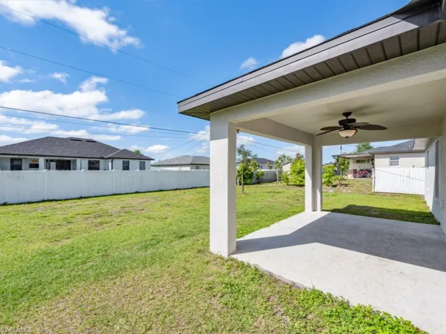 Covered lanai looks over a spacious backyard.